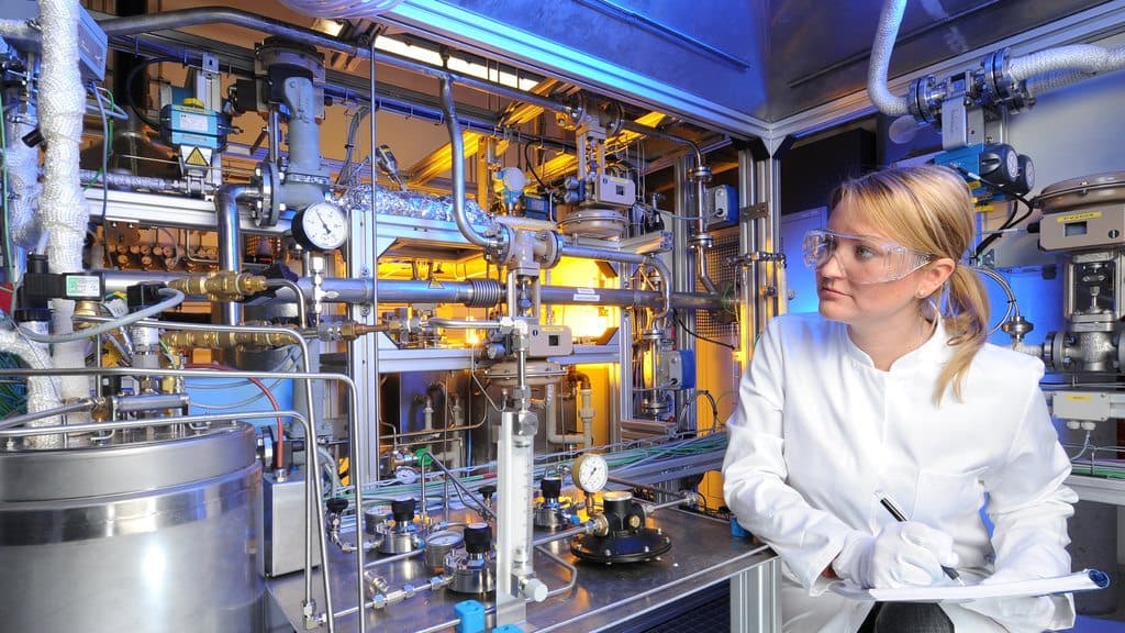 Scientist beside a process development pilot plant