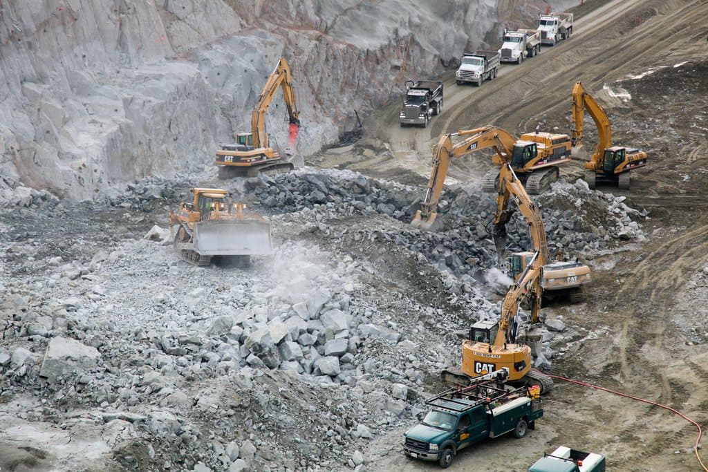 Excavators working an open quarry face