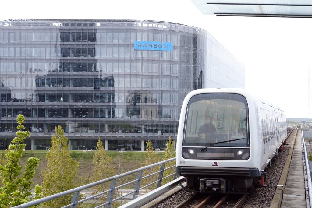 Driverless metro train passing a modern office building