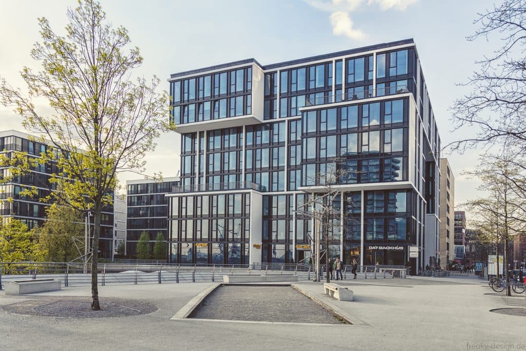 Modern glass office buildings around a paved courtyard