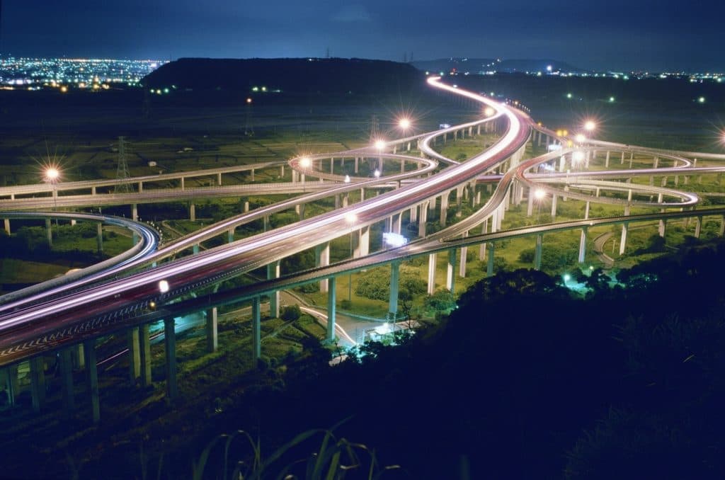 Light trails of traffic on a highway interchange at night