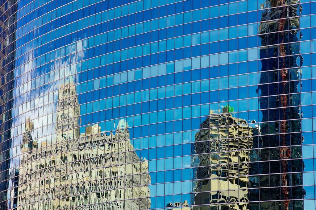Glass office tower reflecting the city